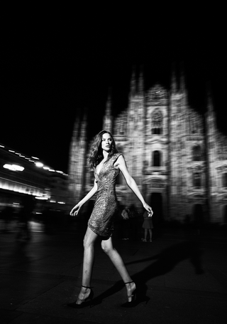 Black and white image of a model in motion in front of the Duomo di Milano