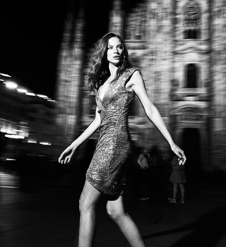Black and white image of a model in motion in front of the Duomo di Milano
